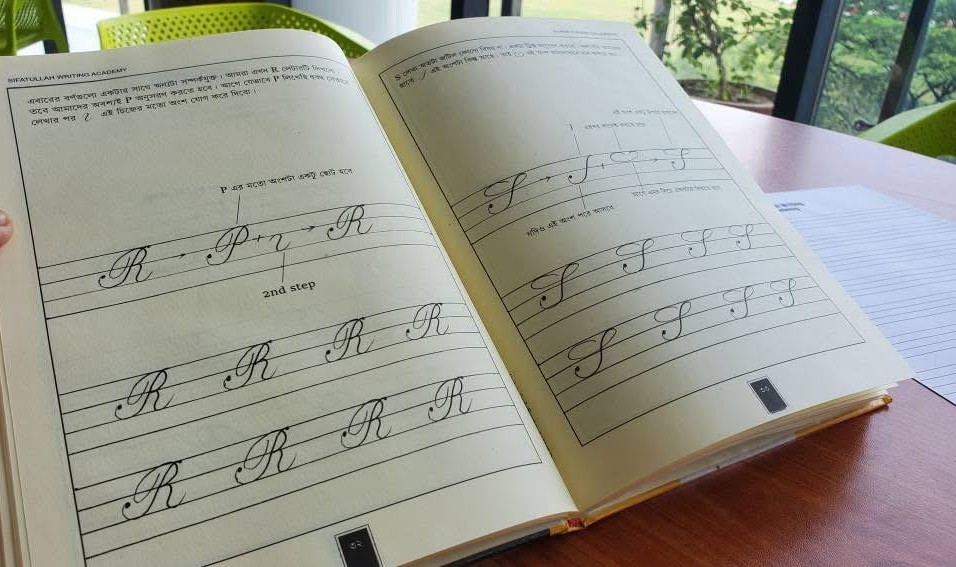Inside the book: pages ৩২ and ৩৩ showing how cursive capital R and S are formed step by step, with guided tracing practice lines
